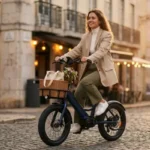 Mulher ocidental estilosa, com blazer bege e calça oliva, sorri ao andar de e-bike dobrável azul marinho com cesta de vime e flores numa rua de pedras na golden hour, evocando uma cena de K-Drama Urbano. Foco em e-bike dobrável barata.